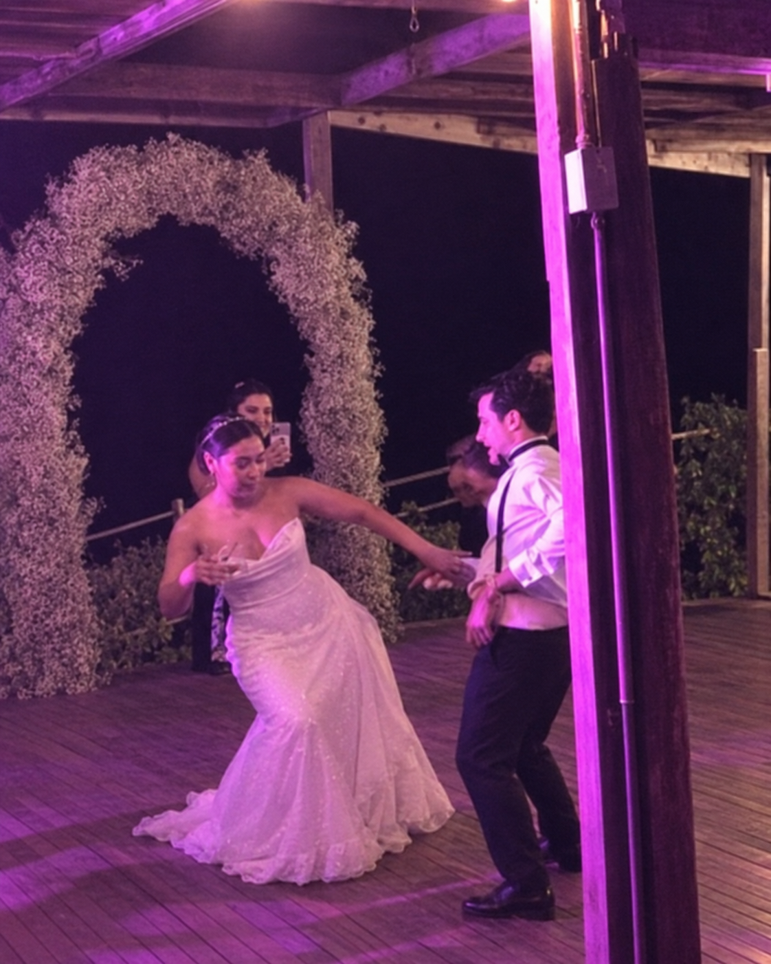 A couple dancing beside the floral arch